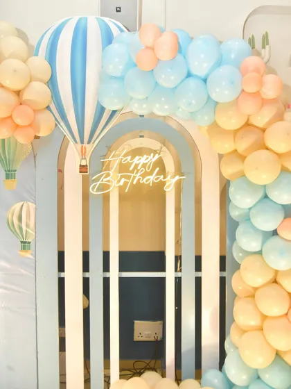 Another detail of the hot air balloon theme, showing the 'Happy Birthday' neon sign.