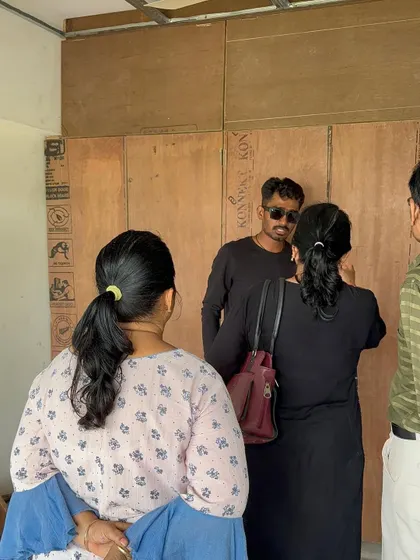 A discussion with clients on-site, right next to the raw plywood structures that will soon become their custom furniture.