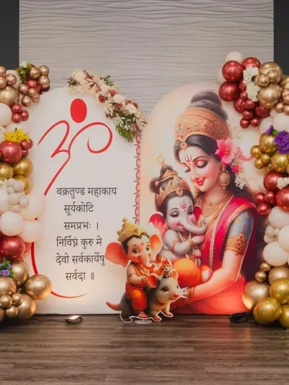 For this special baby shower, we blended tradition with modern decor. The backdrop features a beautiful illustration of Maa Parvati with baby Ganesha, framed by a rich maroon and gold balloon garland to give it a divine and celebratory feel.