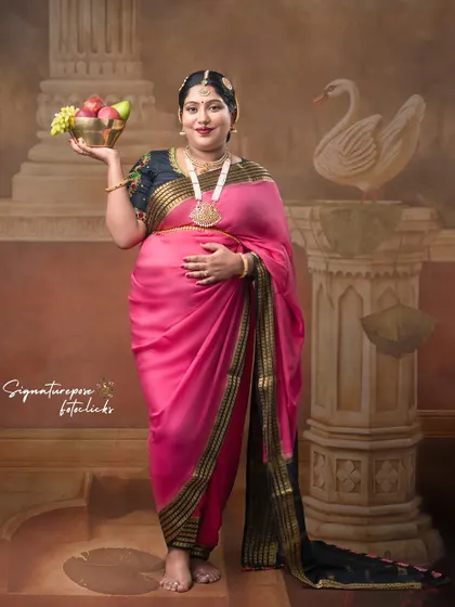 This standing pose captures the elegance of the saree drape and the mother's graceful posture.