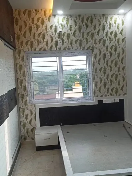 A bedroom wall with a subtle green leaf pattern, creating a calm and restful environment.