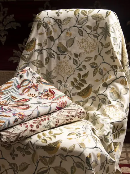 Introducing "Nature's Symphony," a collection of handwoven fabrics with intricate nature-inspired embroidery. This image shows a variety of floral and fauna motifs perfect for upholstery or drapery.