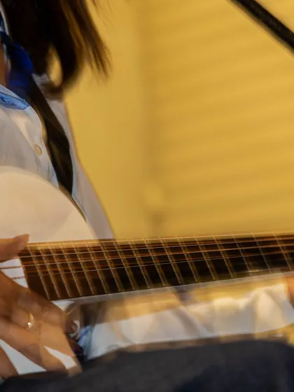 My hand and white guitar fill the frame in this close view from the same private-celebration performance.