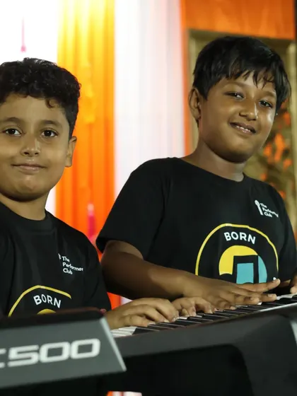 **Piano Duo in Action.** Two of our young pianists share a keyboard during a live performance. Our curriculum encourages collaboration and gives students experience playing with others.