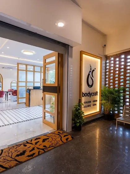 The entrance to our Yelahanka, Bengaluru clinic and salon. The design features a blend of modern and warm elements, like the jali partition and comfortable seating, to make you feel at ease.