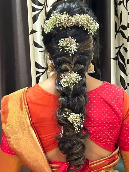 A textured braid decorated with clusters of baby's breath, creating a modern and delicate look.