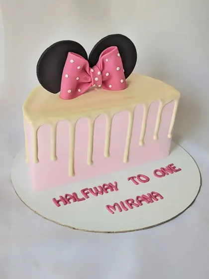 A Minnie Mouse half-birthday cake. This cute design is shaped like half a cake, with a pink drip and a big Minnie bow.