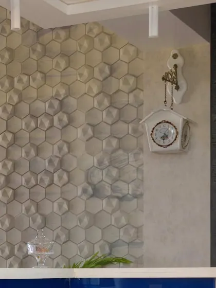 Texture adds depth and character. This image details the 3D hexagonal wall tiles used as a backsplash, creating a unique and visually engaging feature wall in the kitchen.