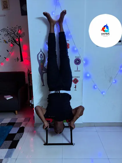I am demonstrating a headstand using a bench, showing how to build core strength and improve circulation safely. The festive lights add a nice touch to the focused atmosphere.