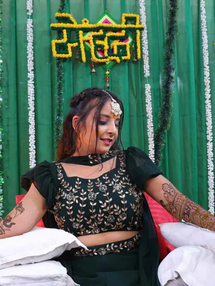 A candid shot of a bride during her mehndi ceremony, with the beautiful henna art on display.