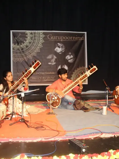 A student ensemble performing on stage, showing the variety of instruments we teach and incorporate, including sitar and tabla.