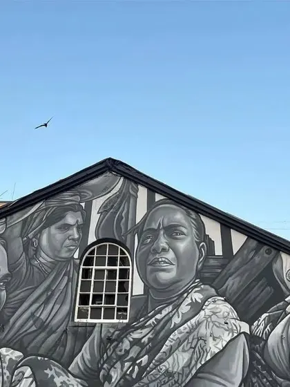 The top of the warehouse at Sassoon Dock, painted in a striking black and white style. This mural showcases the faces of the women who are the backbone of the fishing community.