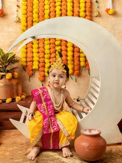 This little Krishna is posing sweetly on a crescent moon prop, a popular and whimsical element in my Janmashtami setups.