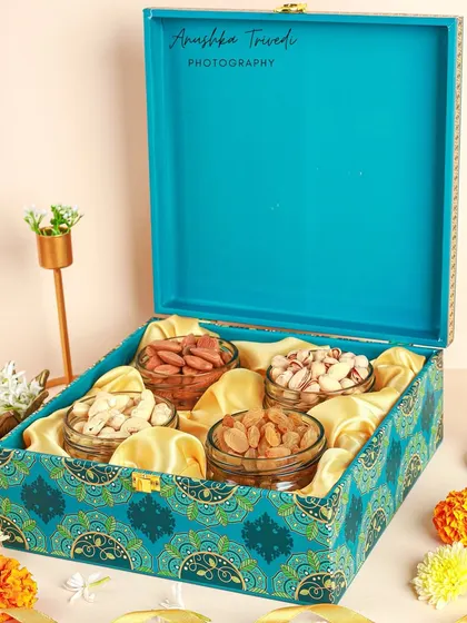 Another angle of the teal dry fruit hamper, showing the box opened to reveal the contents against a satin lining.