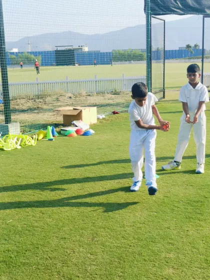 Two young players work together on a catching and throwing drill, building teamwork and communication skills.