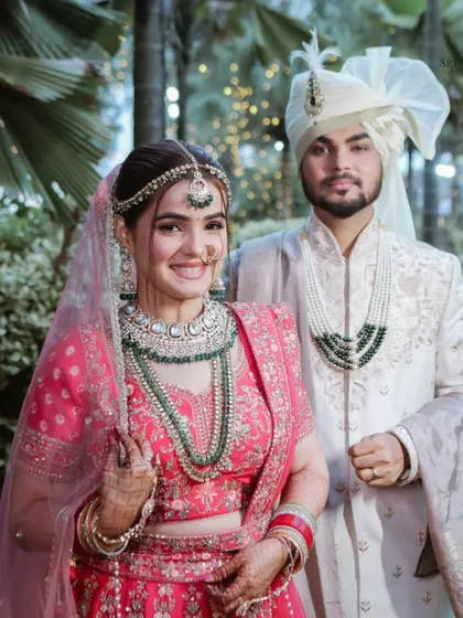 This beautiful client testimonial photo highlights our commitment to excellence. The bride looks absolutely radiant in our pink lehenga and green jewelry.