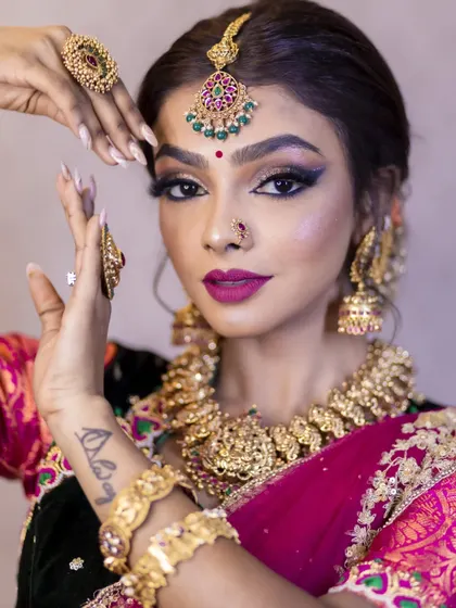 A vibrant and festive look for Deepawali. The model is wearing a traditional antique gold finish necklace set that contrasts beautifully with her dark green and pink half-saree.