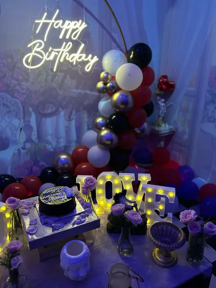 A close-up of the cake table in the 'Smokey Lounge', featuring 'LOVE' marquee letters and beautiful floral arrangements.