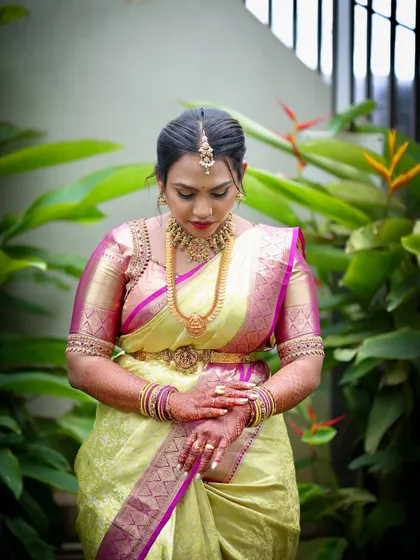 This candid shot captures the elegance of the traditional South Indian bridal look, with the rich silk saree, temple jewellery, and waist belt (vaddanam).
