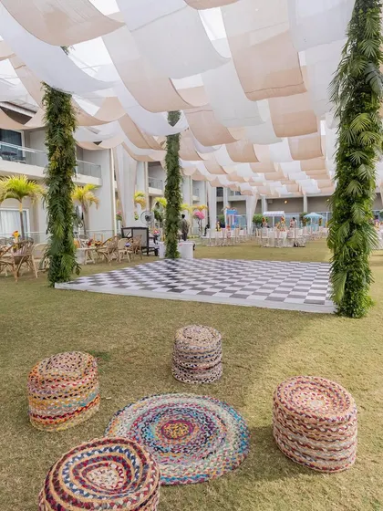 Casual and rustic seating arrangements with jute poufs and rugs, providing a relaxed space for guests to mingle at the carnival event.