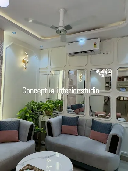Another angle of the living room, highlighting the interplay between the geometric wall panel and the mirrored panel, which adds depth and reflects light beautifully.