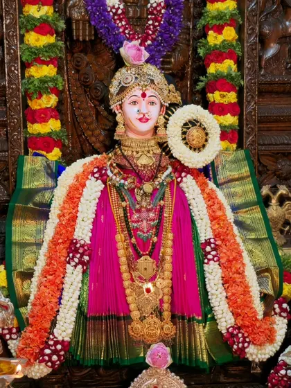 A detailed look at the Varamahalakshmi idol's alankara. I share techniques for layering sarees, garlands, and jewelry to achieve this traditional and grand look.