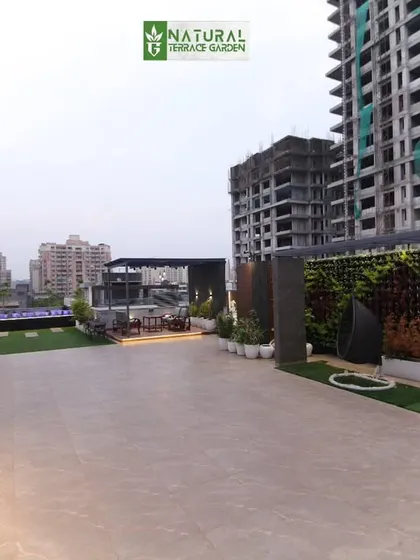 A wide daytime view of our completed project on a large terrace in Sushant Lok, Gurgaon, showing multiple structures and green spaces.
