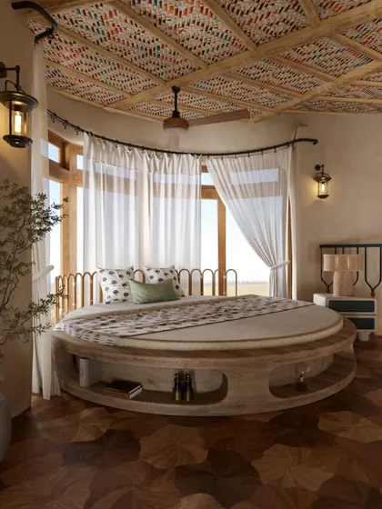 This view of the circular bed shows the vibrant, patterned textile used for the ceiling. This detail, combined with the wooden floors and natural light, creates a room that is both playful and deeply connected to an earthy aesthetic.