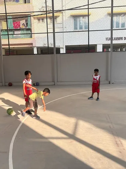 A young player practices a wheelbarrow race, a fun drill to build strength and teamwork in our basketball classes.