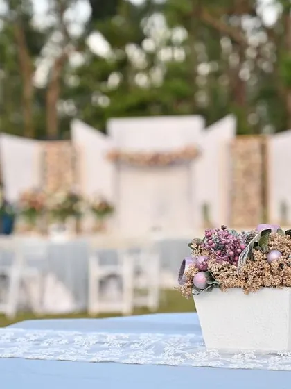 A closer look at the table setting for a modern outdoor wedding. A simple lace runner and a pastel floral centerpiece create a look of serene and tranquil elegance.