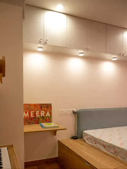 Spotlights installed under overhead cabinets provide excellent task lighting for a child's study area and bed.