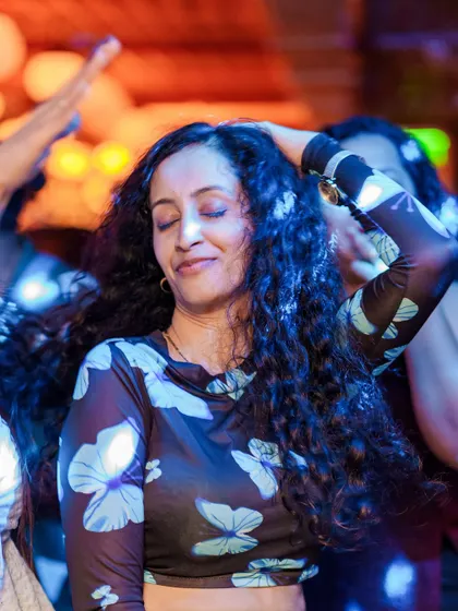 A moment of bliss on the dance floor. A guest feeling the music, lost in the nostalgic beats of the night.