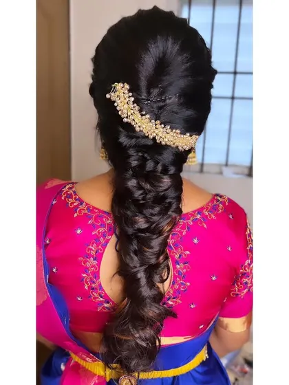 A beautiful messy fishtail braid created for an engagement. The pearl hair accessory at the crown adds a touch of sophistication to this modern hairstyle.