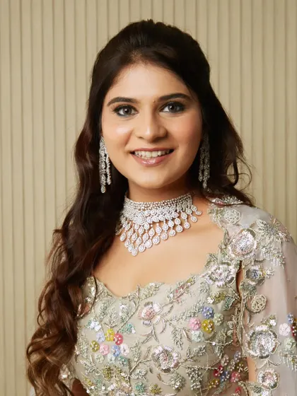 A closer portrait of the student's work, highlighting the clean makeup and radiant smile.