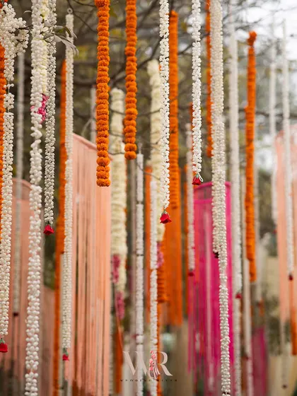 A beautiful detail of the hanging floral and ribbon decorations. The mix of traditional marigold garlands with modern fabric ribbons in a pastel palette created a unique and festive look.