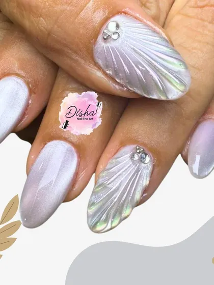 Elegant and ethereal. This design features a pearlescent white base with sculpted 3D shell textures and a single rhinestone accent for a touch of understated sparkle.