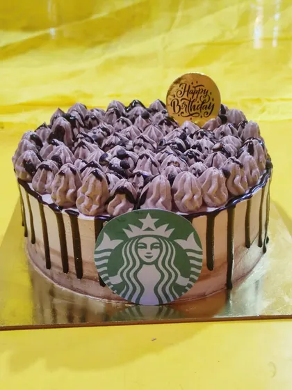 For the coffee lover, this Starbucks-themed cake is the perfect treat. It features the iconic logo and is topped with coffee-flavored buttercream dollops and a chocolate drip.