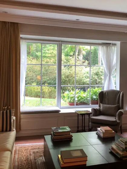 The sitting area for the Chairman's office in this international firm was designed to merge indoor comfort with outdoor serenity. Expansive windows frame the lush garden, maximizing natural light and creating a calm, inspiring environment for strategic thinking and relaxation.