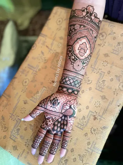 A beautiful bridal arm piece with a peacock, kalash, and other traditional symbols.