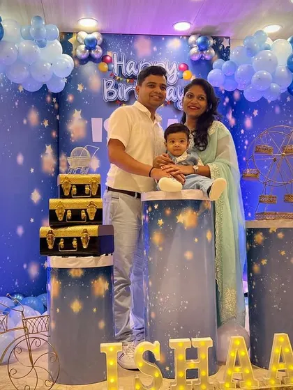 A family photo showing the full scale of the 'Ishaan's Birthday' stage setup. The illuminated letters of the name add a personalized and sparkling touch to the overall decor.