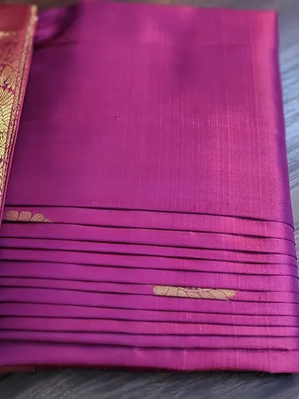 The back of a magenta silk saree, showing the neatness of the box fold.