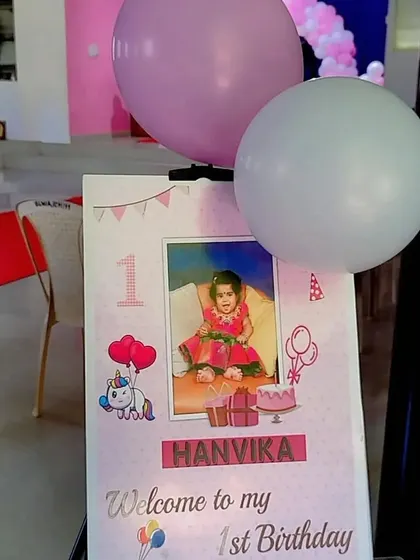 A cute welcome sign for a first birthday party, featuring a photo and unicorn graphics.