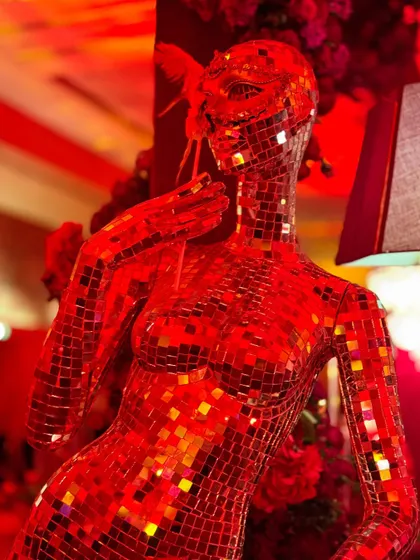 This masquerade-themed party was drenched in dramatic red lighting, with intricate floral centerpieces, candelabras, and even a mirrored mannequin adding to the mysterious and glamorous vibe.