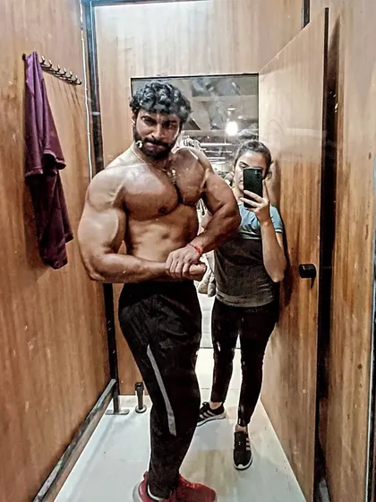 Don't mind the mirror, just look at the body. A confident side chest pose.