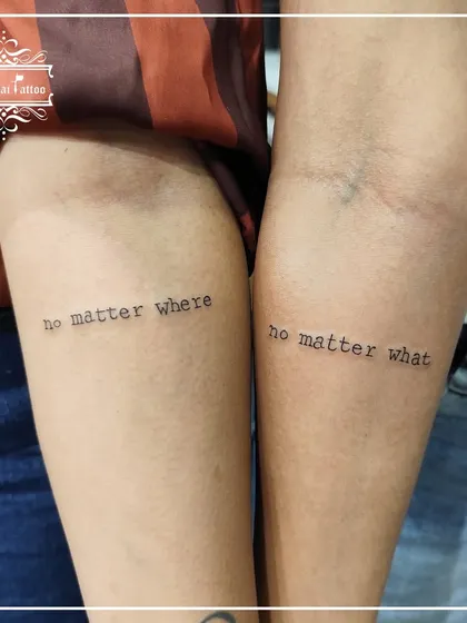 A matching friendship tattoo that reads "no matter where" on one arm and "no matter what" on the other. It's a simple, powerful promise inked forever.