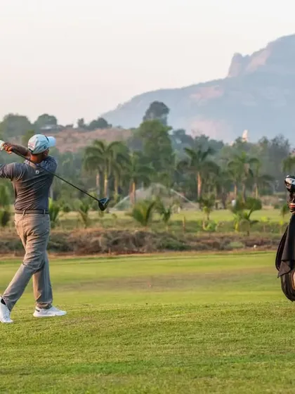 A player completes a full swing with a driver, with our course's mountain landscape in the background. This image showcases a perfect moment of action on the fairway.