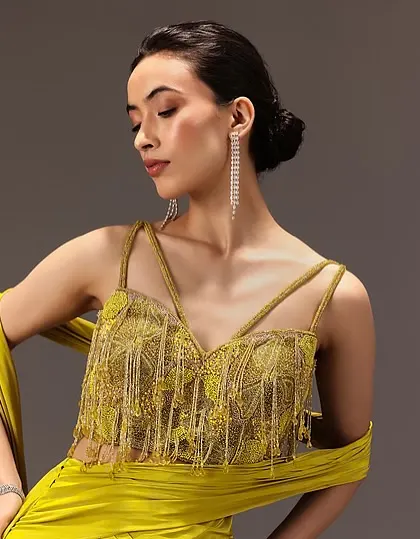 A chic and modern look with a neat low bun. This hairstyle is perfect for showcasing statement earrings and the intricate details of the yellow fringed top.