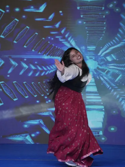 A student performs a lively folk dance, celebrating cultural heritage on the Memorabilia stage.