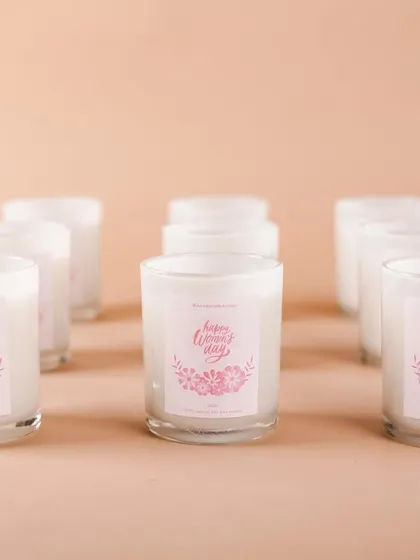 Scented candles with custom "Happy Women's Day" labels. Small, thoughtful items like these make any gift hamper feel more special.