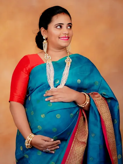 A glowing portrait of the mom-to-be. The makeup is traditional, with defined eyes and radiant skin, perfectly suited for a baby shower or festive maternity shoot.